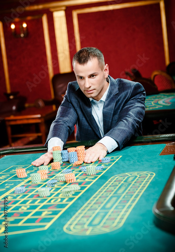 Photo: Gambler stakes piles of chips at the roulette table Gambler stakes piles of chips at the roulette table