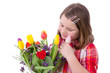 Child girl delights in tulip flowers