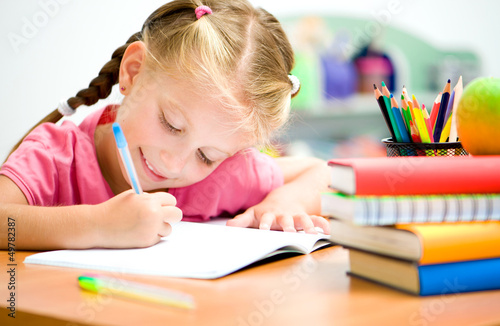 Photo: little girl is writing little girl is writing