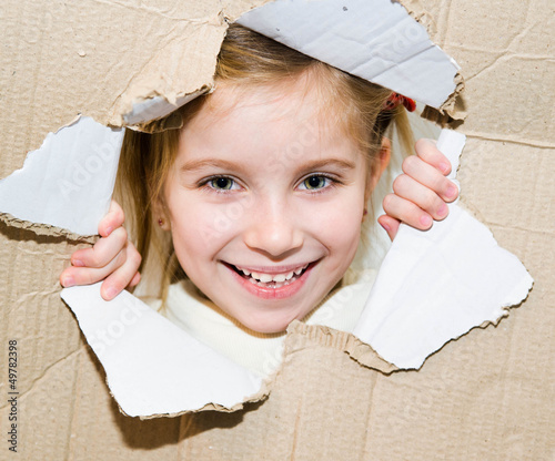 Photo: kid in torn paper hole kid in torn paper hole