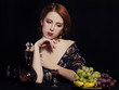 Portrait of beautiful rich women with grapes.