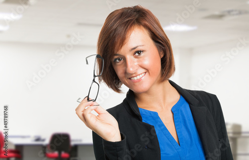 Photo: Smiling woman holding her eyeglasses Smiling woman holding her eyeglasses