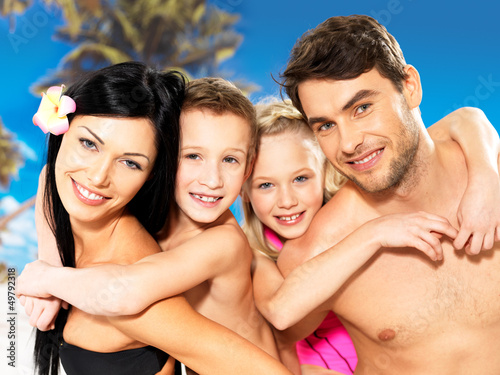 Photo: Happy family with two children at tropical beach Happy family with two children at tropical beach