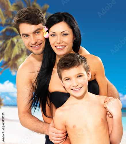 Photo: Happy family with child at tropical beach Happy family with child at tropical beach