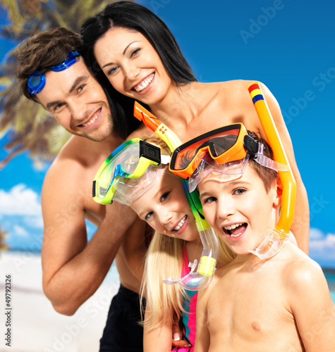 Photo: Happy fun family with two children at tropical beach Happy fun family with two children at tropical beach