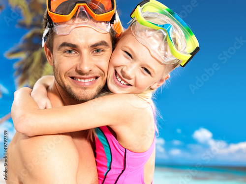 Photo: happy smiling father hugs daughter at tropical beach happy smiling father hugs daughter at tropical beach