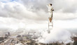 Businesswoman standing on ladder