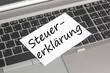 Computer mit Schild Steuererklärung