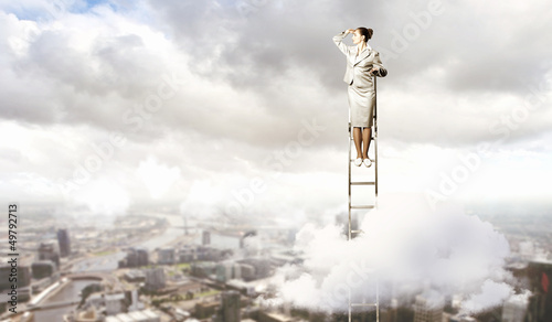 Photo: Businesswoman standing on ladder Businesswoman standing on ladder