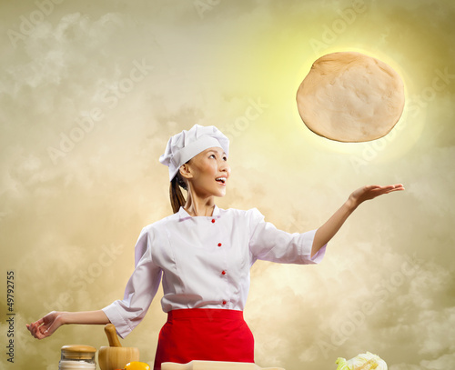 Photo: Asian female cook making pizza Asian female cook making pizza