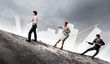 Three business people pulling rope