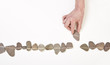Hand schiebt Stein in Linie