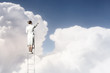 Businesswoman standing on ladder