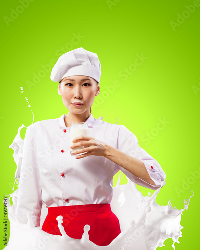 Photo: Asian female cook against milk splashes Asian female cook against milk splashes
