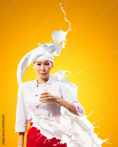 Photo: Asian female cook against milk splashes Asian female cook against milk splashes