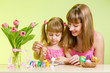 mother and daughter kid painting easter eggs