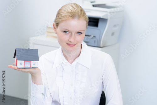 Photo: businessfrau präsentiert haus businessfrau präsentiert haus