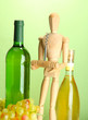 Mannequin with corkscrew and wine bottle, on green background