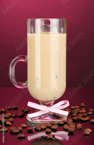 Photo: Cold coffee with ice in glass on color background Cold coffee with ice in glass on color background