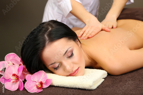 Photo: Beautiful young woman in spa salon getting massage with spa Beautiful young woman in spa salon getting massage with spa