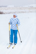 Happy Caucasian woman skiing in wintry field alone