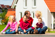Happy family sitting in front of home