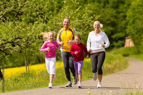 Photo: Family running in the meadow for sport Family running in the meadow for sport