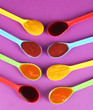 Baby puree in spoons on purple background