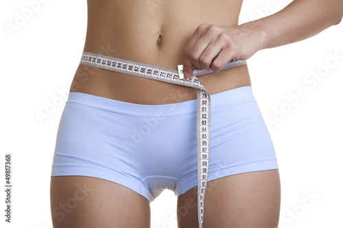 Photo: Woman measuring her waist Woman measuring her waist