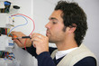 Trained electrician repairing fuse box