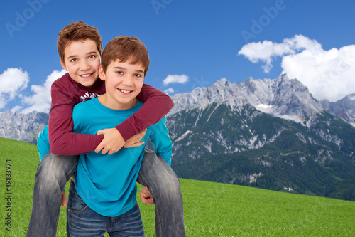 Photo: Ziemlich beste Freunde - Freundliche Jungen huckepack, draußen Ziemlich beste Freunde - Freundliche Jungen huckepack, draußen