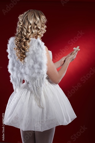 Photo: Back view of angel with crucifix Back view of angel with crucifix