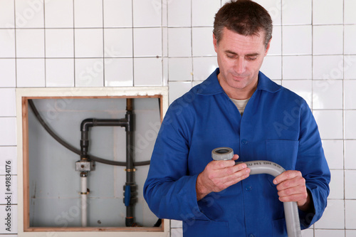 Photo: Skilled worker replacing defective pipe Skilled worker replacing defective pipe