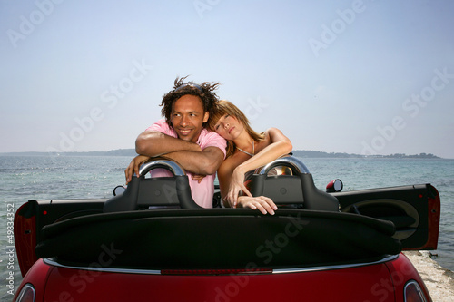Photo: couple on a summer vacation embracing in their car couple on a summer vacation embracing in their car