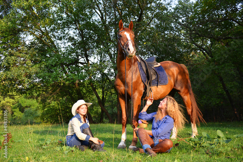 Photo: Two Beautiful Smiling Cowgirls with horse Two Beautiful Smiling Cowgirls with horse