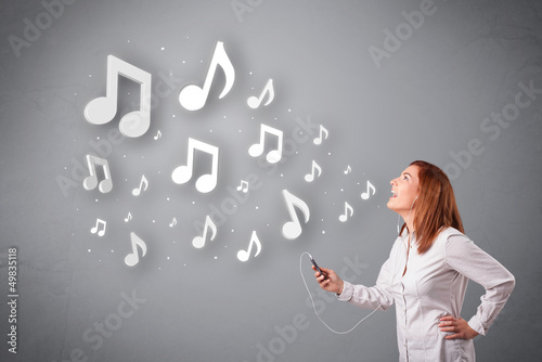 Photo: Pretty young woman singing and listening to music with musical n Pretty young woman singing and listening to music with musical n