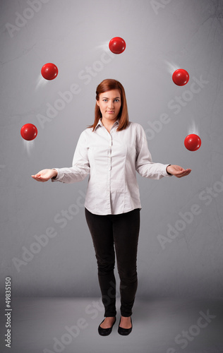 Photo: young girl standing and juggling with red balls young girl standing and juggling with red balls
