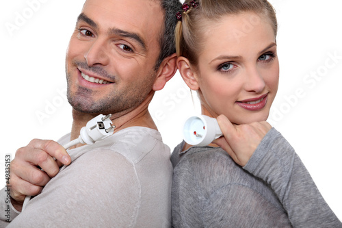 Photo: Couple with electrical plug stood back to back Couple with electrical plug stood back to back
