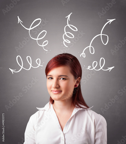 Photo: Young woman thinking with arrows overhead Young woman thinking with arrows overhead