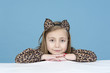 little girl disguised as a leopard, isolated on blue