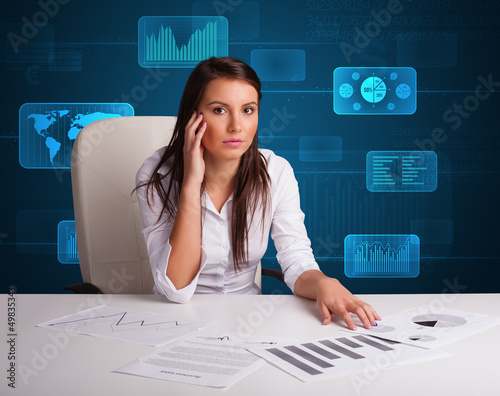 Photo: Businesswoman doing paperwork with digital background Businesswoman doing paperwork with digital background