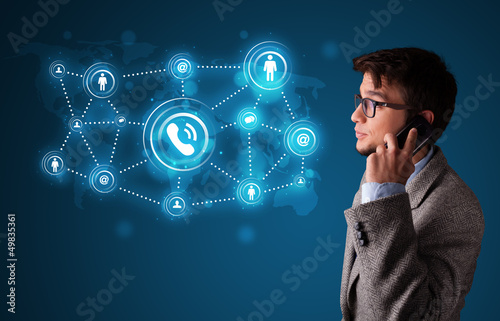 Photo: Young boy making phone call with social network icons Young boy making phone call with social network icons