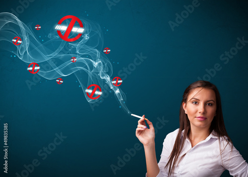 Photo: Young woman smoking dangerous cigarette with no smoking signs Young woman smoking dangerous cigarette with no smoking signs
