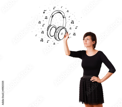Photo: Young girl drawing headphone and musical notes Young girl drawing headphone and musical notes