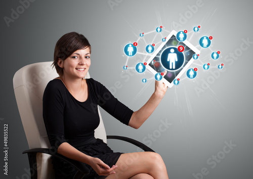 Photo: young woman holding tablet with social network icons young woman holding tablet with social network icons