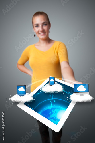 Photo: Young woman holding tablet with modern devices Young woman holding tablet with modern devices