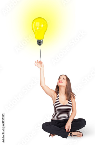 Photo: Happy woman holding a light bulb balloon Happy woman holding a light bulb balloon