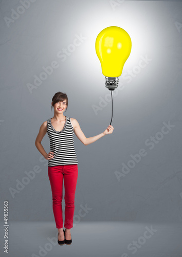 Photo: Pretty lady holding a light bulb balloon Pretty lady holding a light bulb balloon