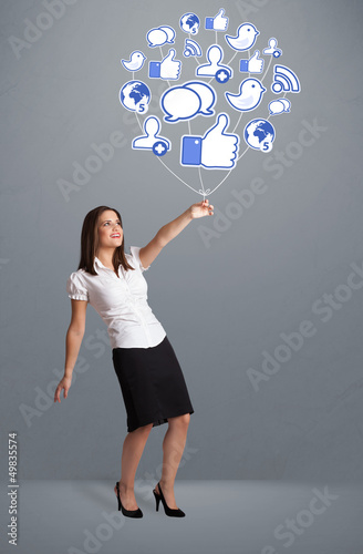 Photo: Pretty woman holding social icon balloon Pretty woman holding social icon balloon