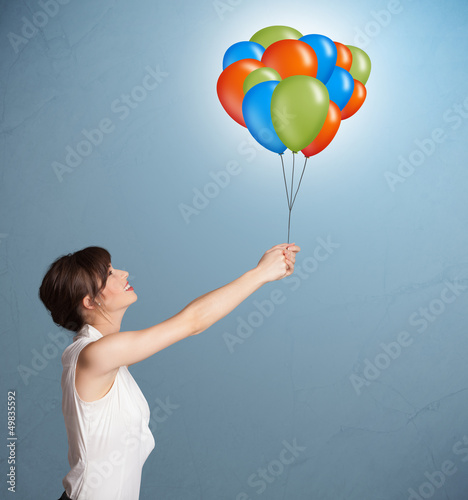 Photo: Young woman holding colorful balloons Young woman holding colorful balloons